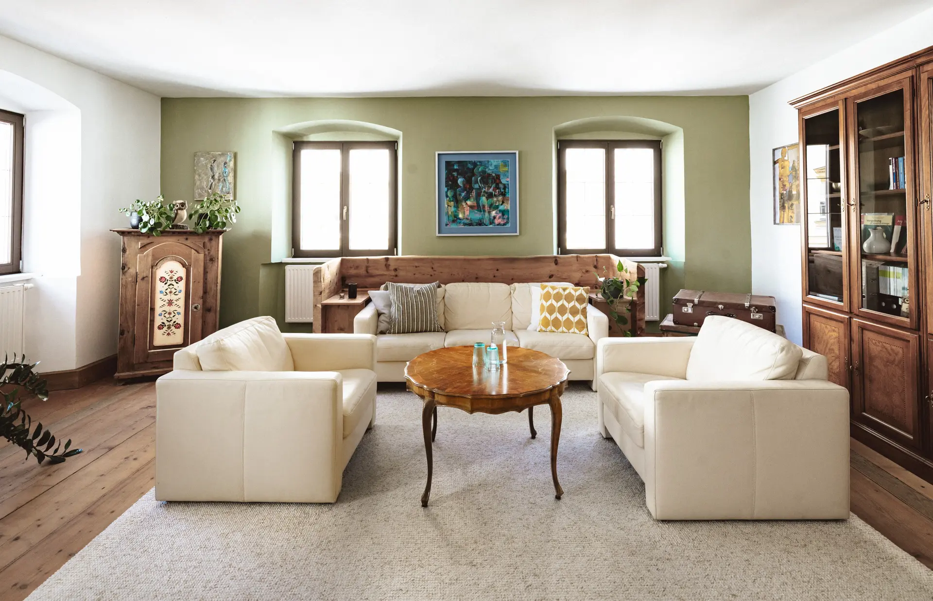 Heller Praxisraum mit Sofas und Holztisch für Psychotherapie